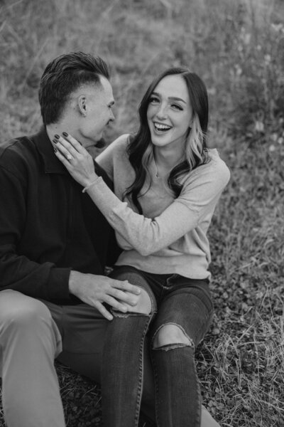 BW Couple, girl sitting on his knee laughing