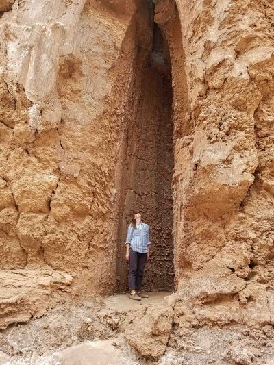 Luxury travel expert Stephanie Dosch inside a narrow rock shaft with textured sandstone walls in Chile's Atacama Desert ©Stephanie Dosch | theViatrix Luxury Travel