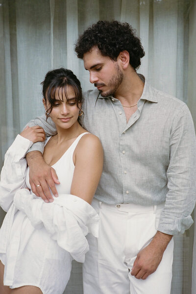 woman in swimsuit with man side hugging her