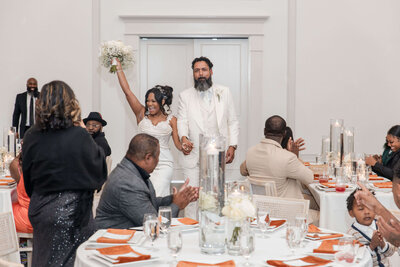 Newlyweds raising glasses in celebration at their beautifully designed wedding reception.