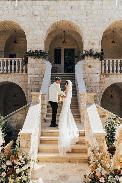 bride and groom standing on stairs