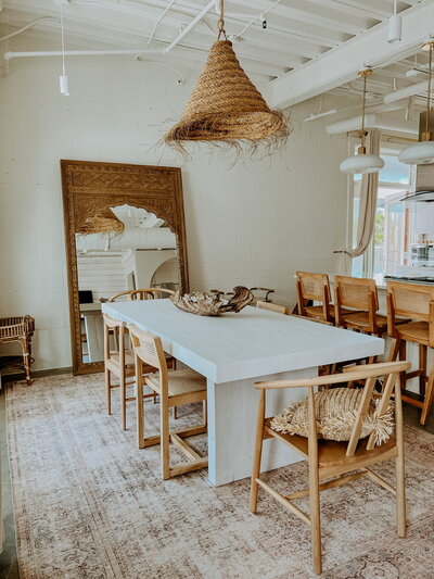 white dining table with wooden chairs and large mirror