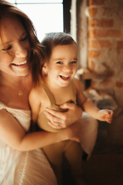 mother holding child laughing