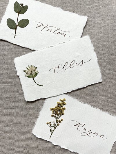 Place cards with pressed flowers and calligraphy