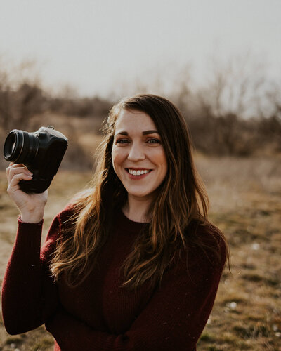 Boise Wedding photographer Katy Kahla smiles with her camera in hand, representing her participation in the Crush Collective wedding expo.