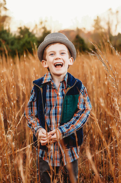 Little boy laughs at the camera during family pictures in Asheville, NC.
