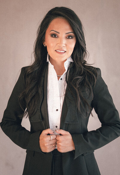 Sandy Chang, confidently against a neutral background, looking directly at the camera with a poised and polished expression.