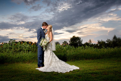 Couple embraces in front of a beautiful sunset at Wildberry Farm