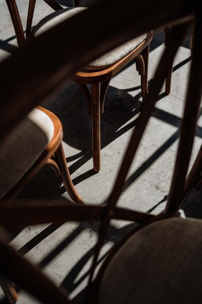 A detail photograph of a wedding chair's shadow on a concrete floor.