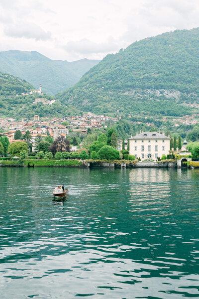 A wedding photo of the couple on a boat on the way to their wedding venue Villa Balbiano