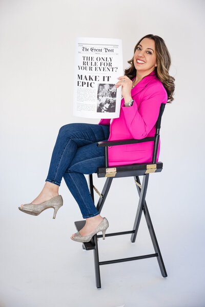 woman holds newspaper while looking at camera