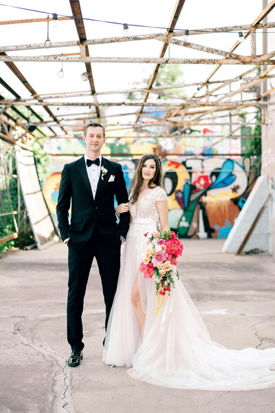 Urban bride and groom stand in outdoor industrial wedding venue in North Texas