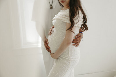 Couple during a maternity photoshoot in Michigan, celebrating their pregnancy