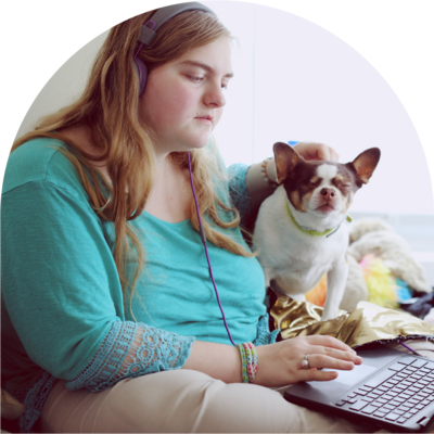 young woman holds dog and laptop