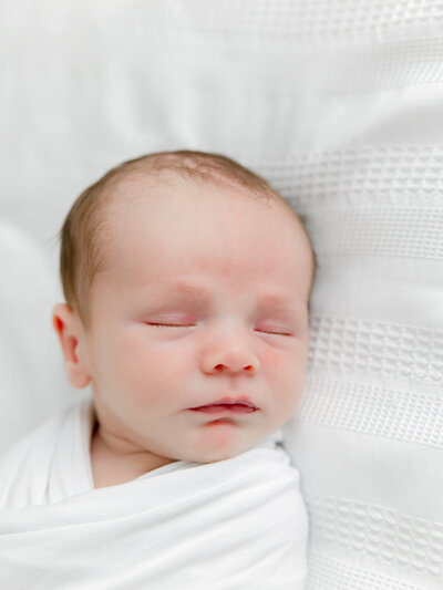 Close up portrait of a newborn baby swaddled in a white blanket in Pennsylvania