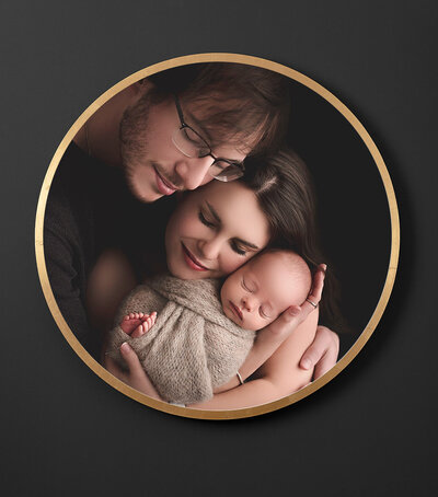 newborn photos with mom and dad on black and gold