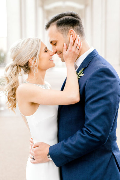 Bride with a fun curled pony tail and groom touch noses just before a kiss, South Bend Wedding Hair and Makeup