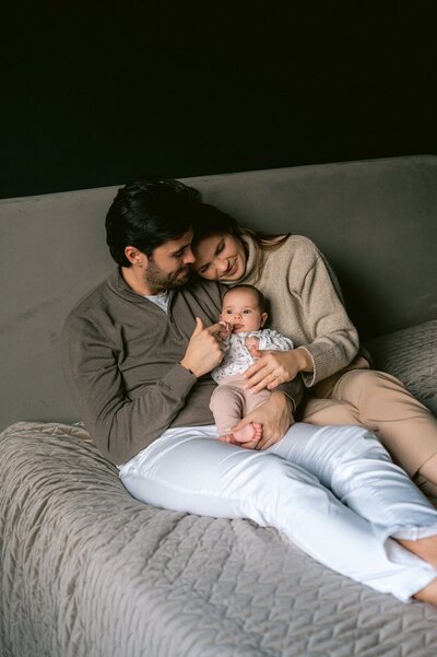 Moeder en vader kijken liefdevol naar hun newborn dochtertje op bed