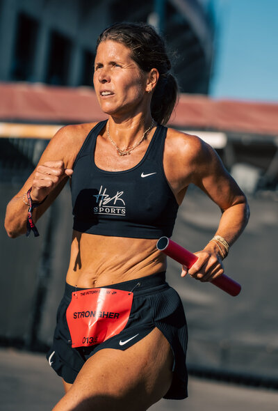 HER Sports Club athlete running with focus during relay training.
