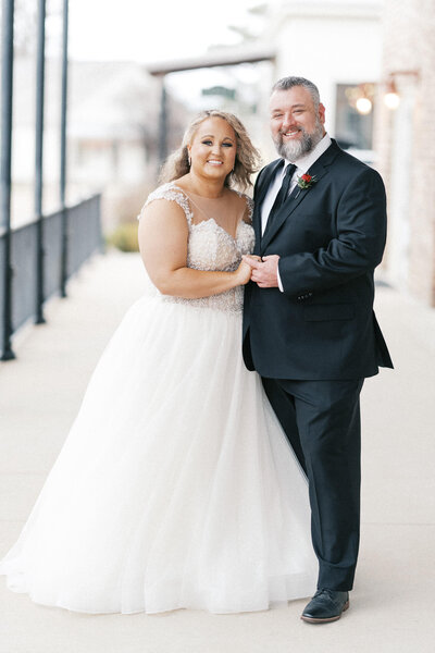Newlyweds pose with joy on their wedding day. Beautiful portrait by Jackson Ms Wedding Photographer.