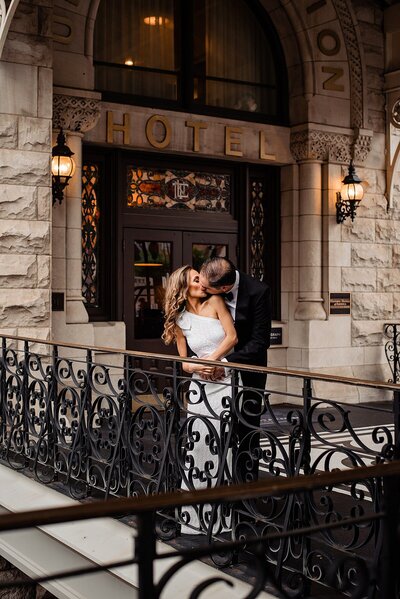 Dramatic photo of bride and groom sharing a kiss along the railings outside of the Nashville Union Station Hotel