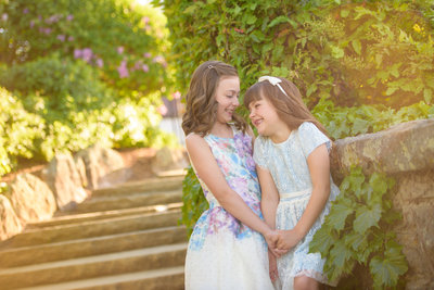 Two sister laugh while looking at each other during portrait session in Boise, Idaho with Tiffany Hix Photography