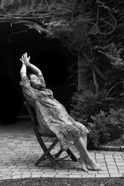 portrait d'une femme enceinte assise sur une chaise en extérieur pendant une séance photo grossesse à la tour du pin par Studio Sensigraphie photographe grossesse isère