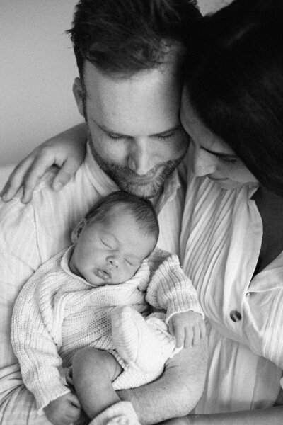 dad holding newborn with toddler