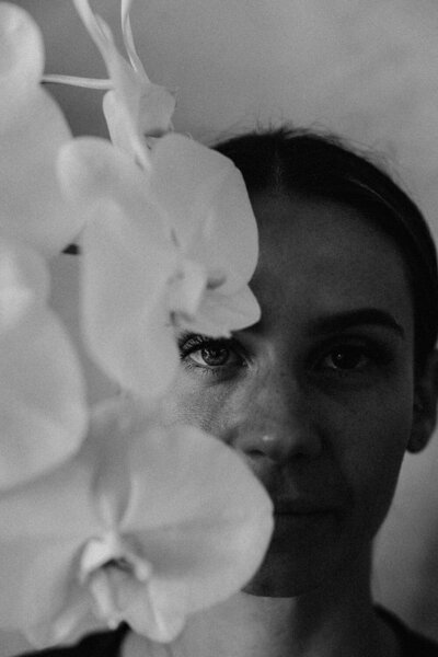 Creative brand photography using flowers to create an emotive black and white headshot