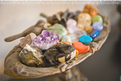 A bowl holding various colors of spiritual crystals