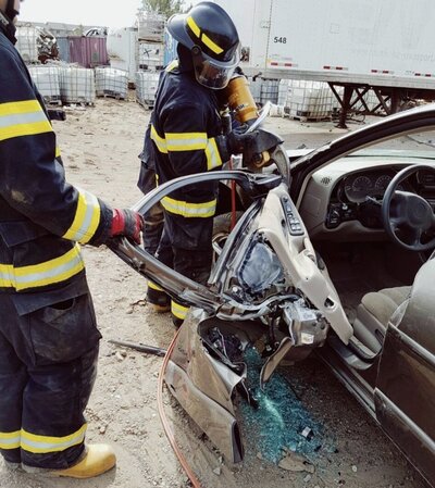 Victoria Gegalow performing vehicle auto extrication as a firefighter, demonstrating emergency response skills
