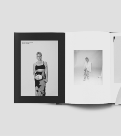 A editorial fashion magazine spread showing a model holding a an oval clutch. The left page displays the text 'Spring/Summer 2024 Styling Edition' above the model, and the right page features another image of the same model in a white blazer dress sat on a stool