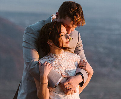 Photograph of elopement couple embraces while they watch the sunset in Albuquerque New Mexico.