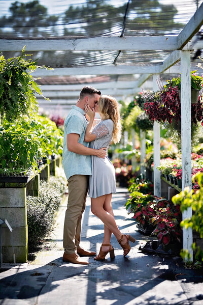Former Marine Veteran and his wife sharing an intimate kiss in a greenhouse in Eastern North Carolina