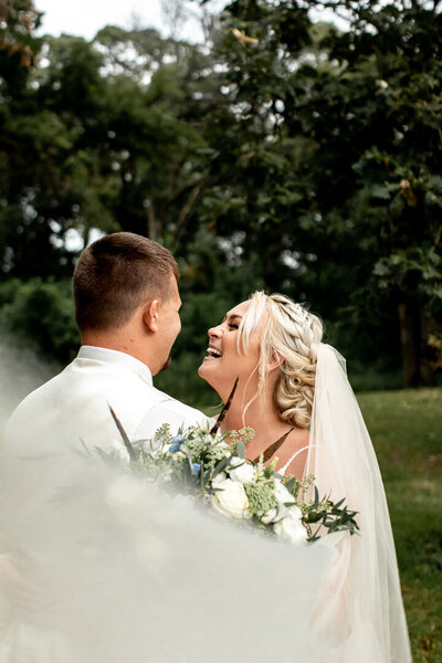 North Iowa bride and groom laughing together outside