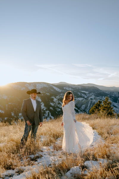 sunlight coming over the mountains as bride and groom dance at their texas elopement