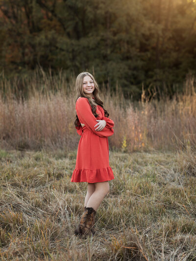 girl in rust dress posing for family photos