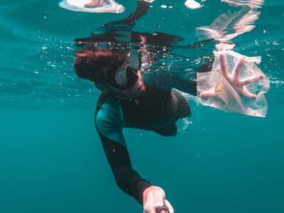 un nageur recoltant les déchets dans l'océan.