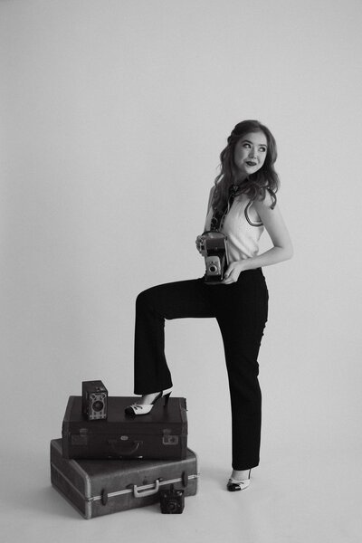 woman standing on suitcase