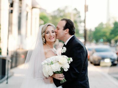 Bride and groom stand outside the Hotel Washington in Washington, D.C., sharing a joyful moment with the city skyline in the background. The elegant, modern wedding was planned by Blue Sapphire Events.