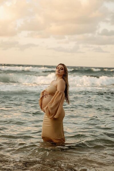 Woman standing in ocean for maternity photo