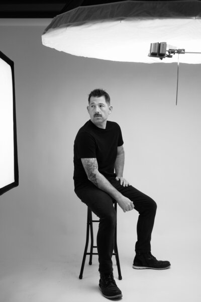 Black-and-white portrait of a photographer in a studio setting