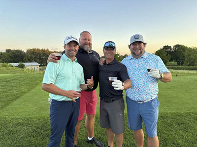 4 guys in golf clothes posing