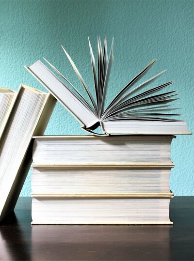 Stack of books with aqua wall