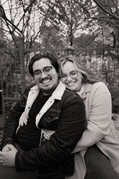 Black and white photo of Javi and Dominique smiling and cuddled together outside — the couple behind Castillo Holliday Photo + Film, film wedding photographers and Super 8 + 16mm wedding films
