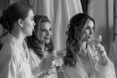 Bride and hen party sipping champagne while getting ready for their wedding in London