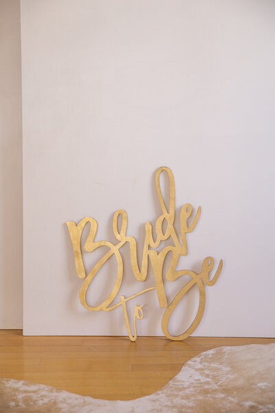 A gold sign that says Bride to Be.
