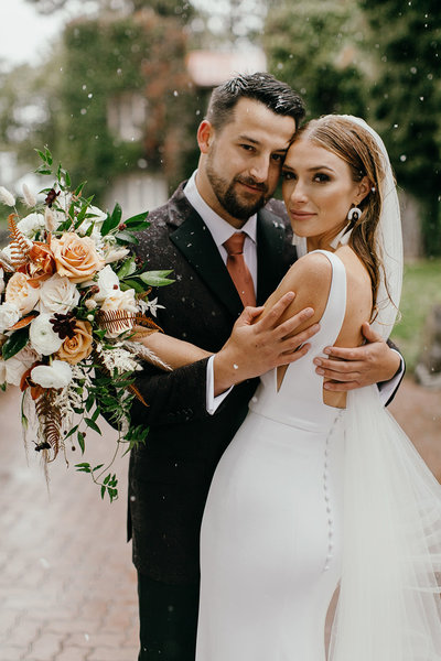 Beautiful bride and groom embrace in the rain on their wedding day in Spokane