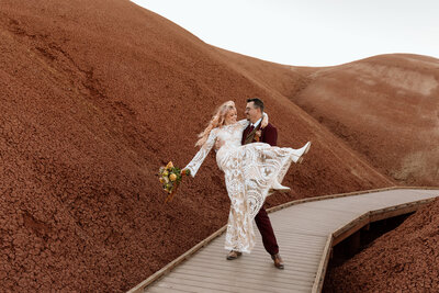 Groom holding bride and swinging her around at Painted Hills.