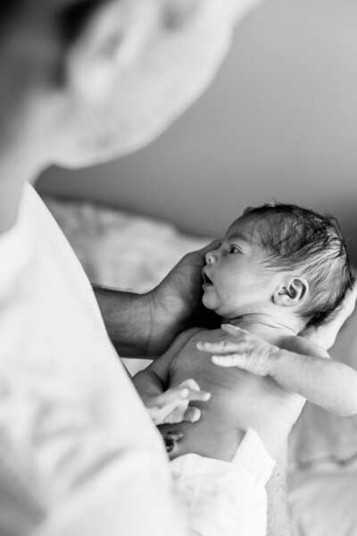 Newborn Photographer, a mother holds her little baby